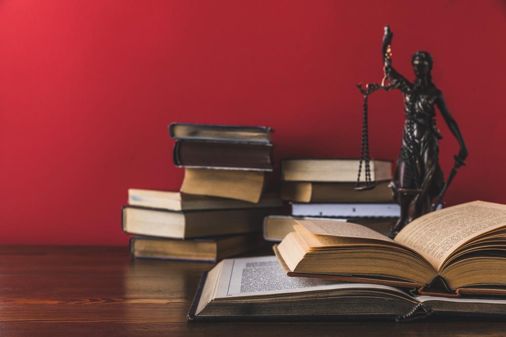 livros jurídicos abertos com estátua de justiça senhora na mesa de madeira, conceito de lei
 - Foto, Imagem