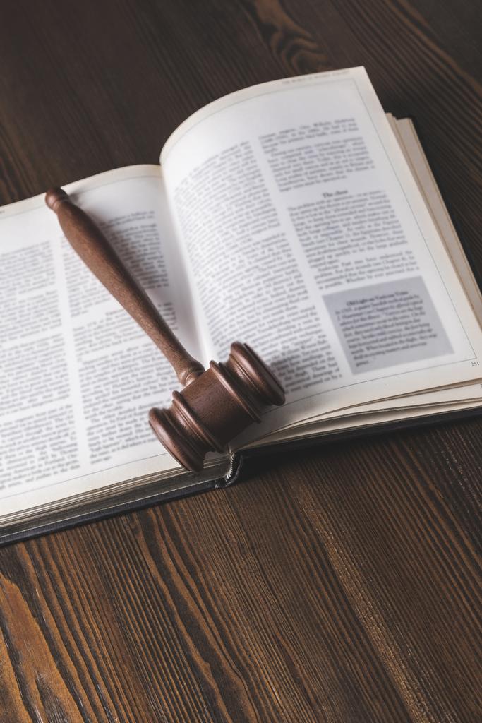 aufgeschlagenes juristisches Buch mit Hammer auf Holztisch, Rechtsbegriff - Foto, Bild