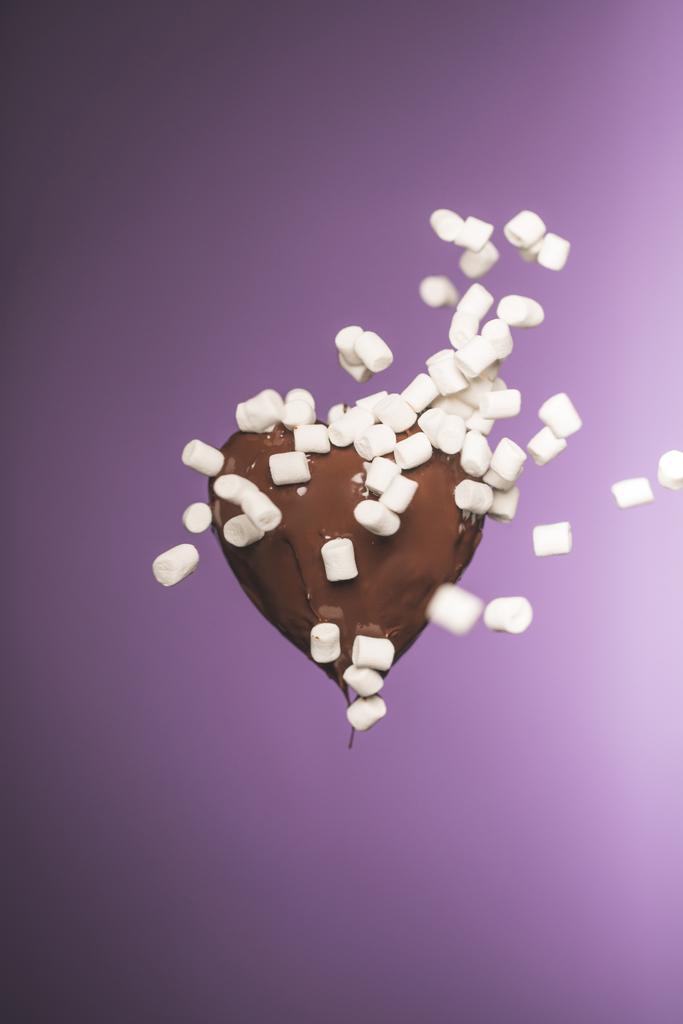 шоколадные конфеты в форме сердца с падающим зефиром изолированы на фиолетовый
 - Фото, изображение