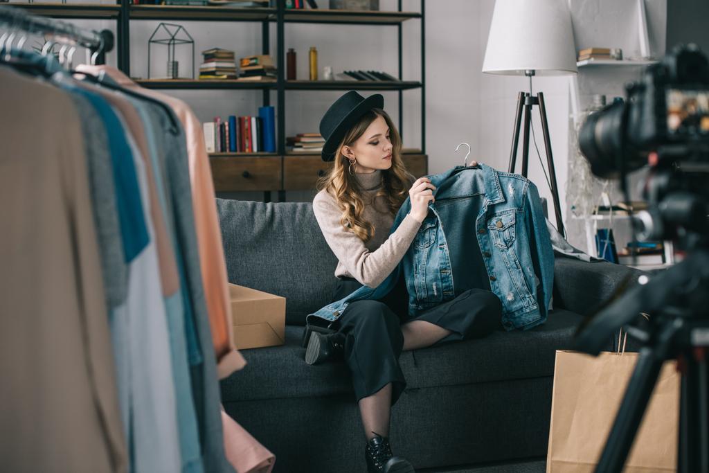 jeune blogueur de mode assis devant la caméra avec veste en jean
  - Photo, image