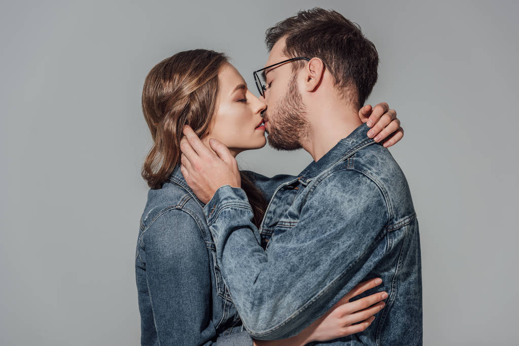 verführerisches junges verliebtes Paar küsst isoliert auf grau - Foto, Bild