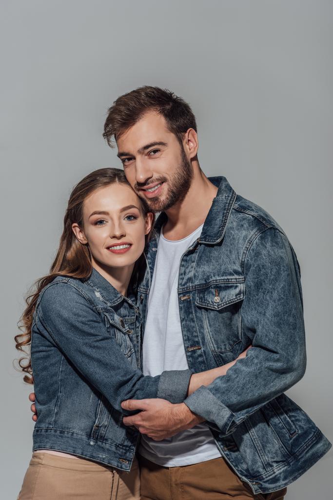 bella felice giovane coppia che abbraccia e sorride alla fotocamera isolata sul grigio
 - Foto, immagini