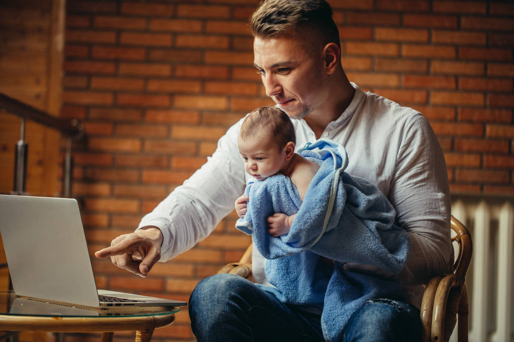 Père avec le nouveau-né travaillant de la maison utilisant l'ordinateur portable
 - Photo, image