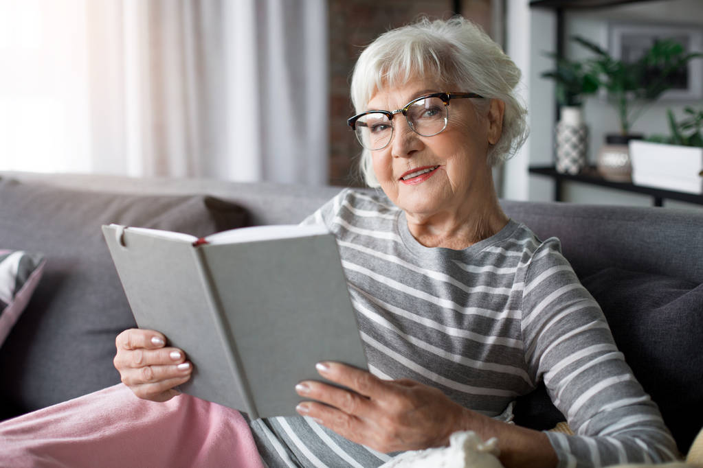 Senior lady holding book with joy - Photo, Image