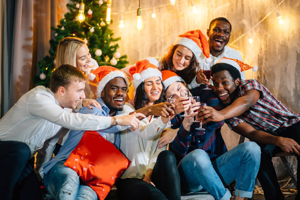 Счастливые друзья с шампанским празднуют Рождество
 - Фото, изображение