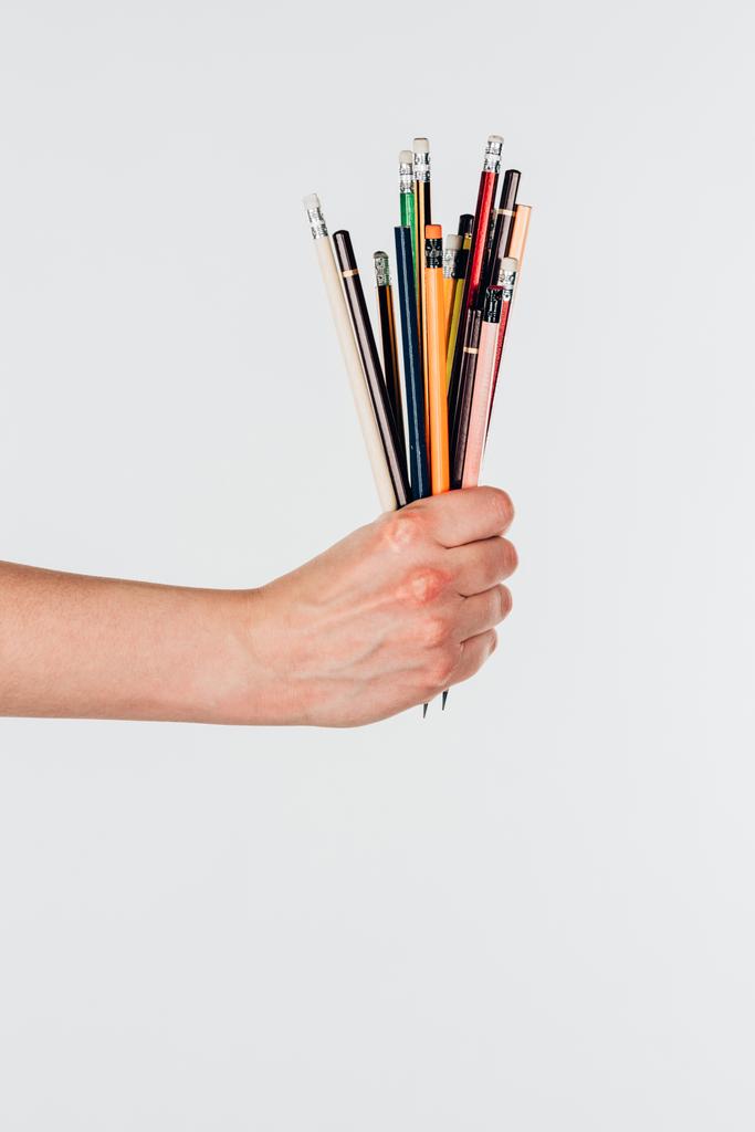 Visão de close-up da mão feminina com lápis coloridos isolados no fundo branco
 - Foto, Imagem