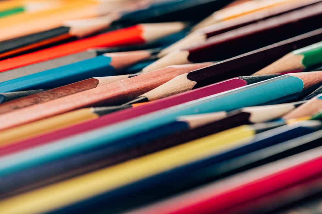 Close-up beeld van kleurrijke potloden in de puinhoop als educatieve achtergrond - Foto, afbeelding