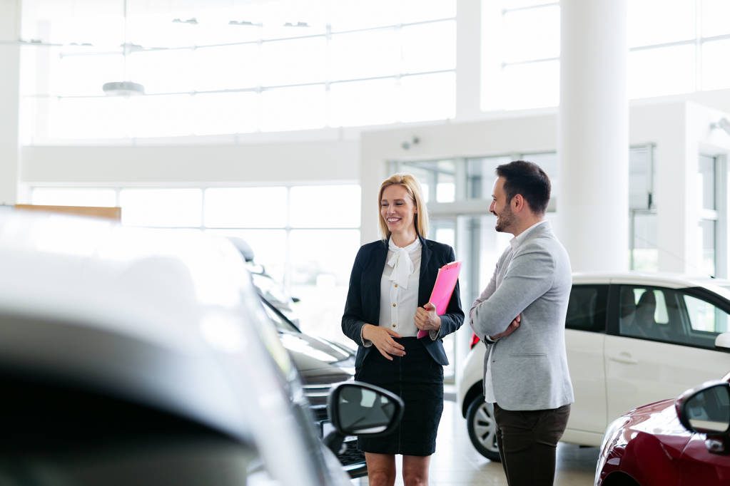 Vendeur professionnel vendant des voitures chez le concessionnaire au nouvel acheteur
 - Photo, image