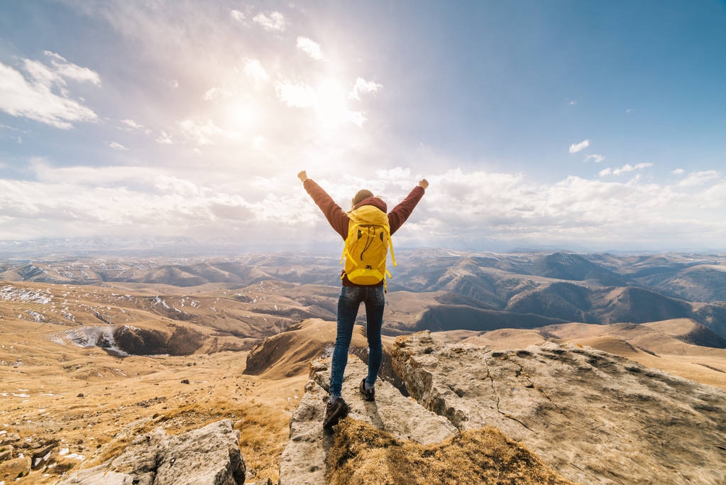 Active dziewczynka z plecakiem żółty przemieszcza się przez góry Kaukazu, podniósł ręce, cieszy się natura - Zdjęcie, obraz