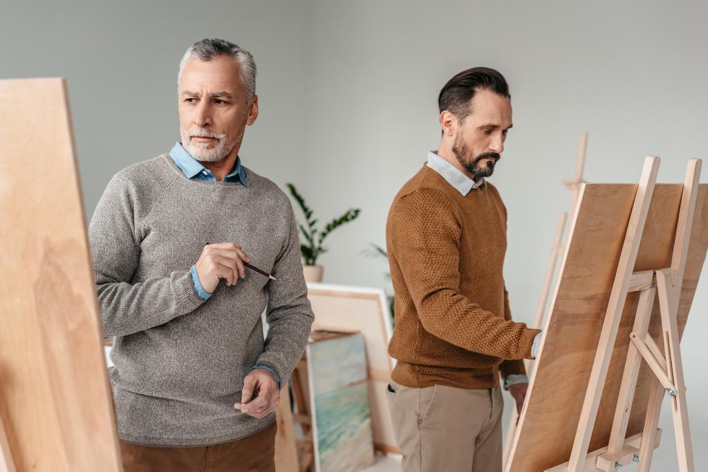 iki yetişkin erkek sanatçı sanat Studio easels boya - Fotoğraf, Görsel