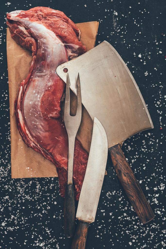 pohled shora syrového vepřového masa s příbory na dřevěném prkénku - Fotografie, Obrázek