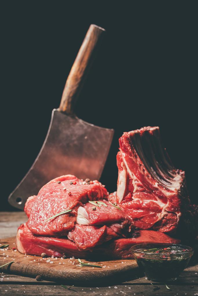 různé syrové maso a sekáček na dřevěném prkénku - Fotografie, Obrázek