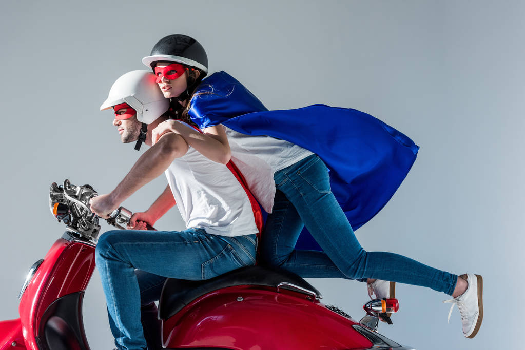 puolella näkymä pari supersankari puvut ratsastus punainen skootteri yhdessä
 - Valokuva, kuva