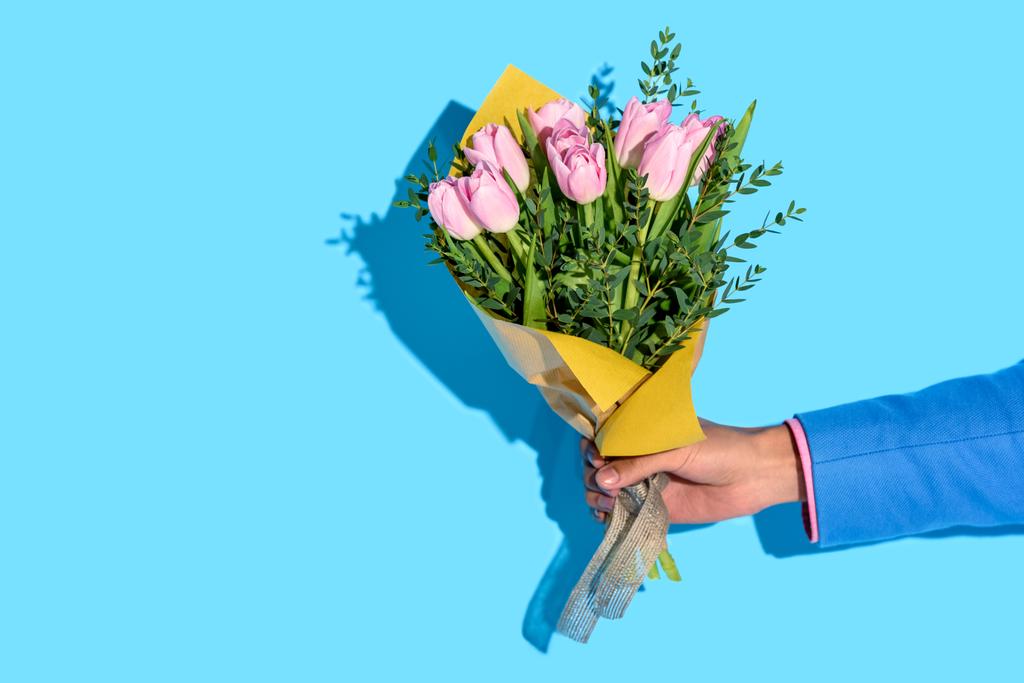 vue partielle de l'homme afro-américain tenant bouquet de fleurs sur fond bleu
 - Photo, image