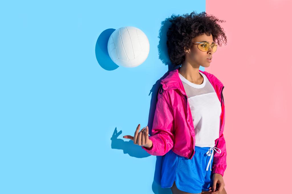 Vonzó lány falnak állandó, és hányt labda, a rózsaszín és a kék háttér - Fotó, kép