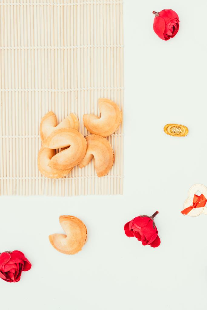 vista dall'alto di biscotti cinesi fortuna e fiori isolati su bianco, concetto di Capodanno cinese
 - Foto, immagini
