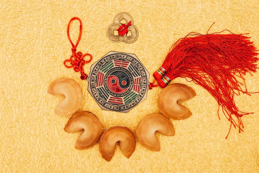top view of chinese talisman surrounded with fortune cookies on golden surface, Chinese New Year concept - Photo, Image