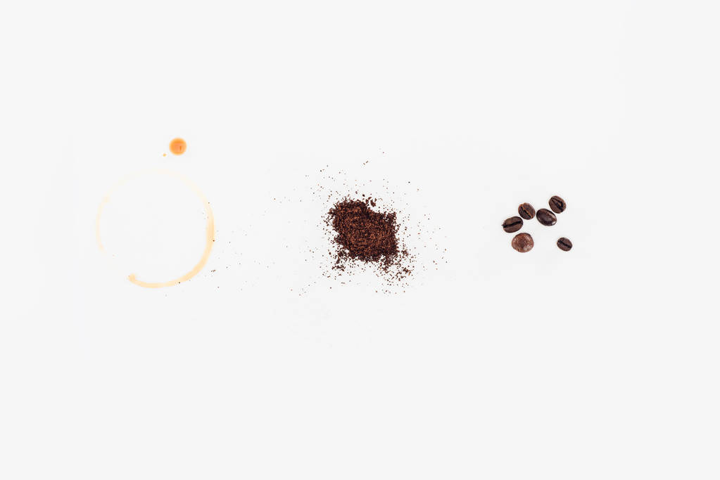 Blick von oben auf geröstete Kaffeebohnen, frisch gemahlenen Kaffee und verschüttetes Kaffeetrinken isoliert auf weiß  - Foto, Bild