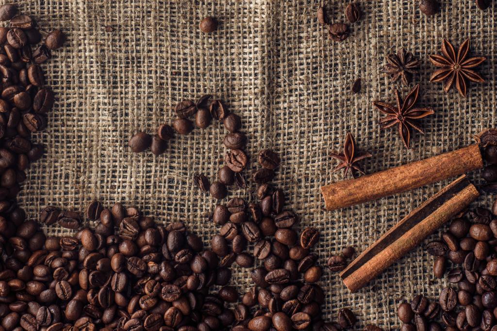 φρυγμένους κόκκους καφέ με ξυλάκια κανέλλα και το γλυκάνισο σε λινάτσα  - Φωτογραφία, εικόνα