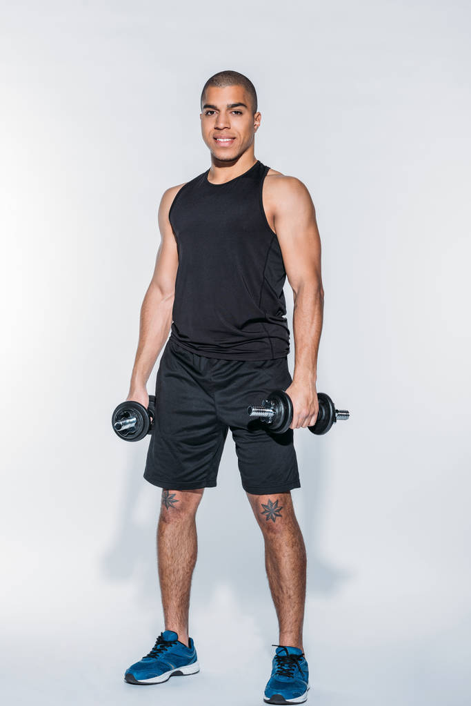 sportif afro-américain souriant debout avec haltères
 - Photo, image