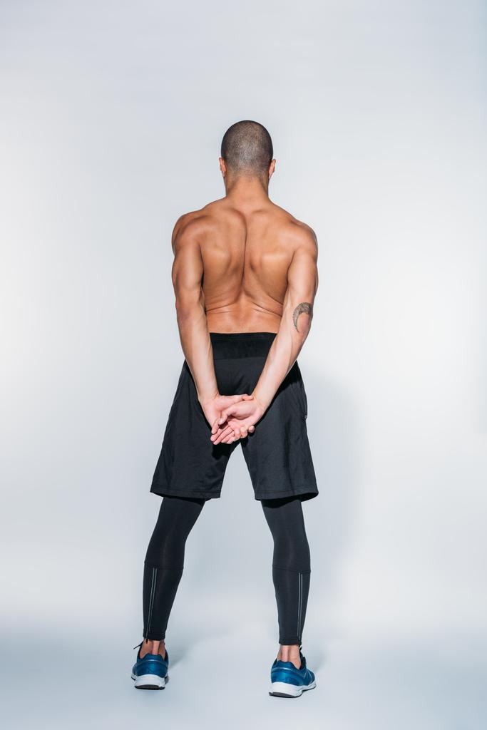 ストレッチ バック上半身裸のアフリカ系アメリカ人のスポーツマンの背面図 - 写真・画像