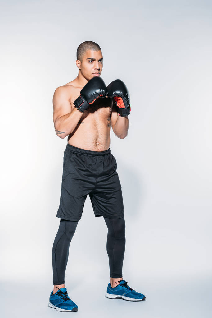 Мускулистый американский спортсмен, стоящий в боксерском стойке
 - Фото, изображение