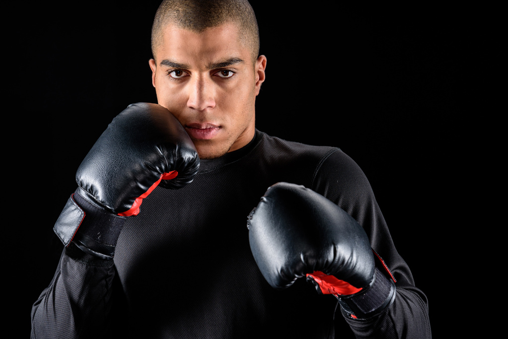 mladí africké americký boxer v černé rukavice, které jsou izolovány na černém pozadí - Fotografie, Obrázek
