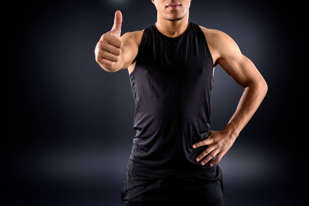 cropped shot of african american sportsman showing thumb up on black - Photo, Image