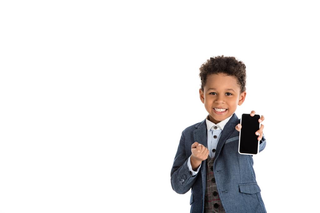 χαμογελώντας Αφρικανικός Αμερικανός παιδί δείχνει smartphone που απομονώνονται σε λευκό - Φωτογραφία, εικόνα