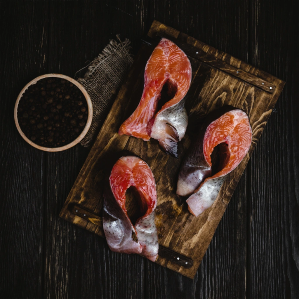 pohled shora plátky lososa ryb na dřevěném prkénku s roucho a pepře na rustikální stůl   - Fotografie, Obrázek