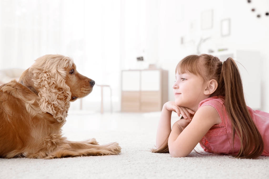 Schattig klein meisje met hond thuis - Foto, afbeelding