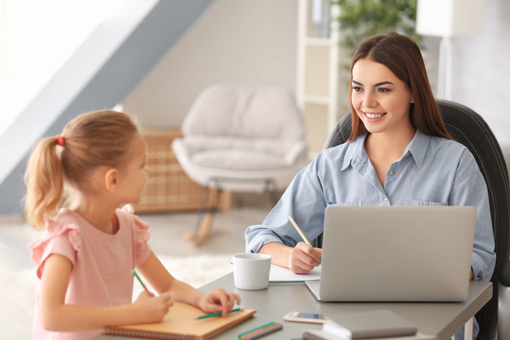 Busy young woman with daughter in home office - Photo, Image