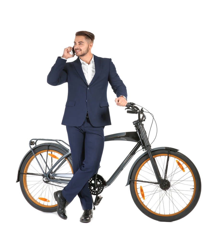 Joven hombre de negocios guapo con bicicleta hablando por teléfono sobre fondo blanco
 - Foto, imagen