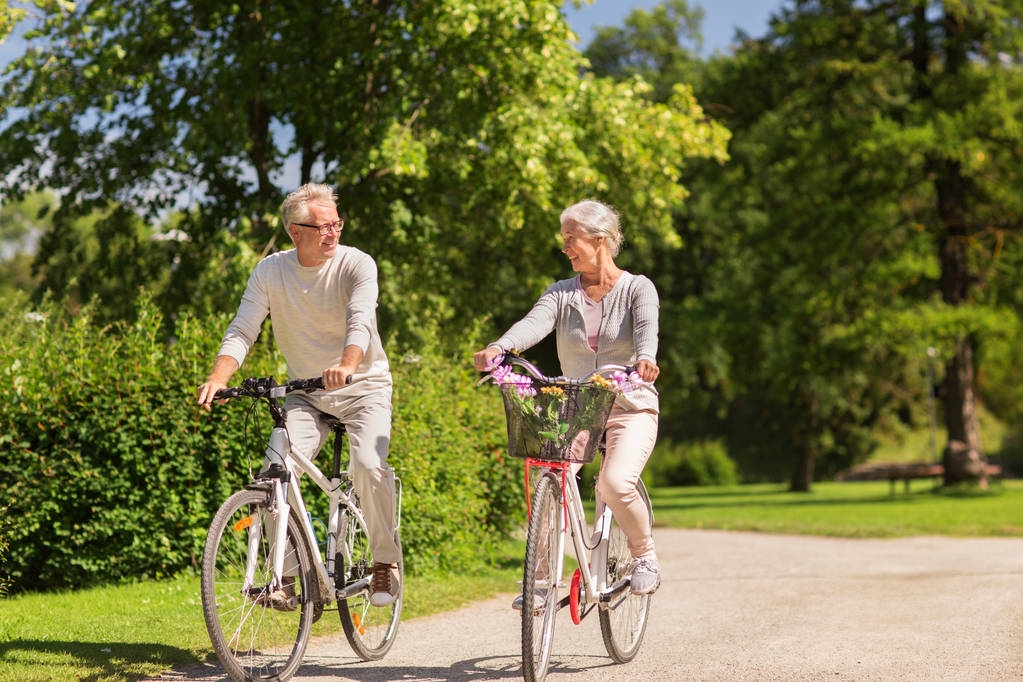 feliz casal sênior andar de bicicleta no parque de verão - Foto, Imagem