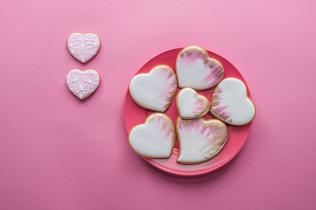 bovenaanzicht van zoete geglazuurde cookies op plaat geïsoleerd op p! NK, st Valentijnsdag concept vakantie - Foto, afbeelding