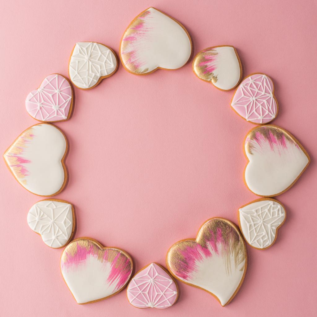 deitado plano com arranjo de biscoitos em forma de coração envidraçado isolado na superfície rosa
 - Foto, Imagem