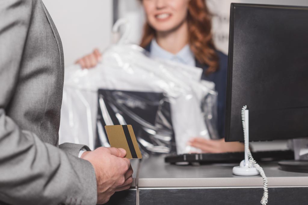 cropped shot of man holding credit card at dry cleaning office - Photo, Image