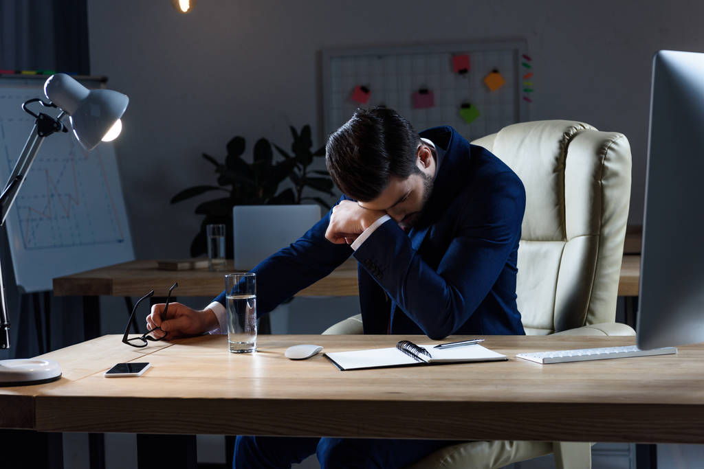 homem de negócios doente com dor de cabeça enquanto trabalhava à noite no escritório
 - Foto, Imagem
