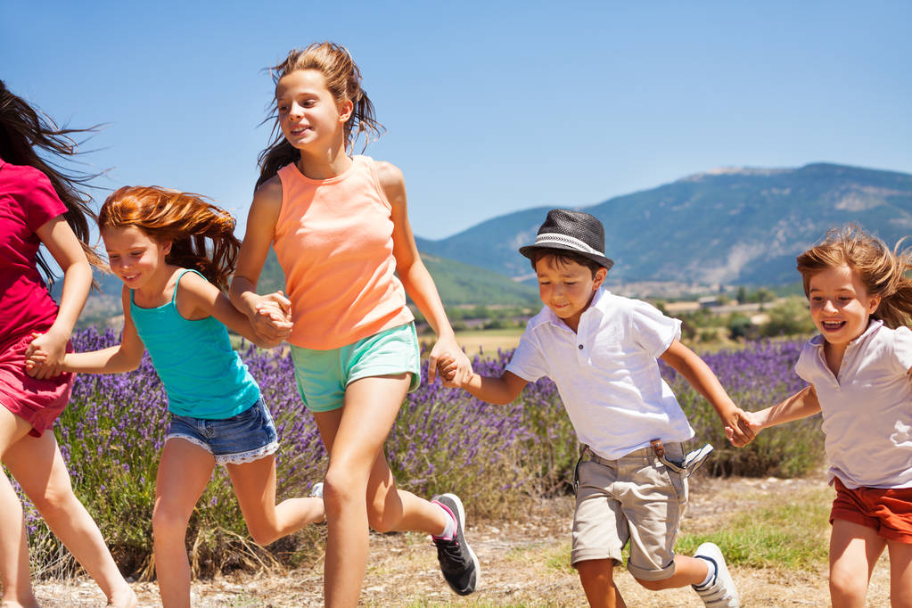 Щасливі хлопчики та дівчатка бігають разом у лавандовому полі
 - Фото, зображення