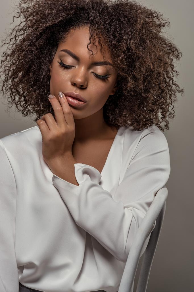 Fiatal pályázati afrikai-amerikai nő a fehér ing ujj ajkak elszigetelt szürke háttér - Fotó, kép