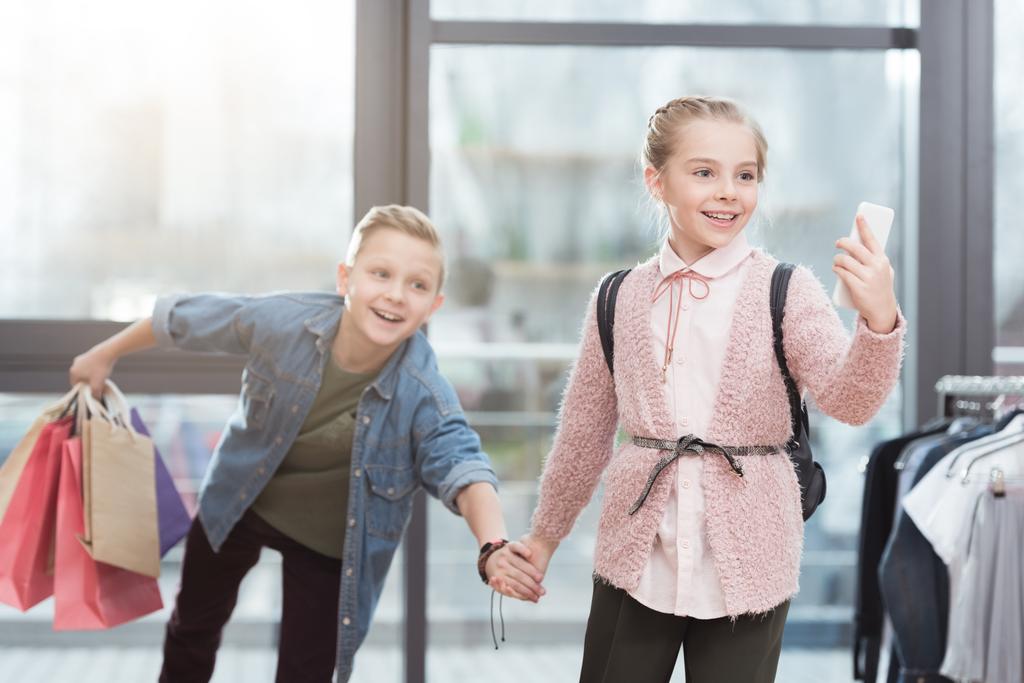 bambini felici con borse della spesa che fanno selfie al negozio
 - Foto, immagini