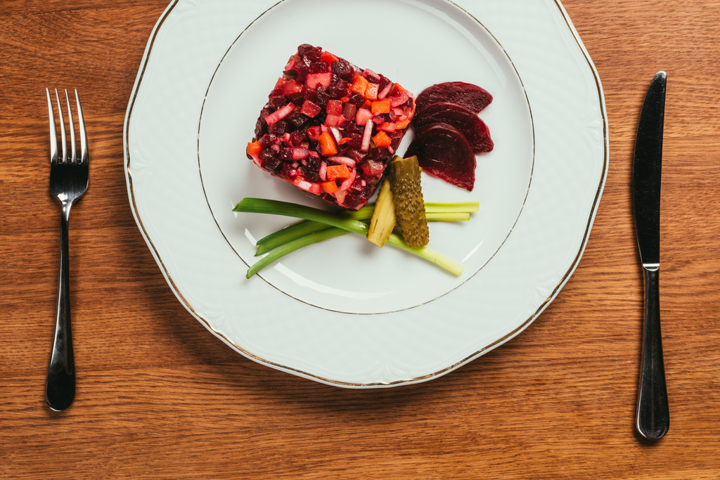 salata salata tabağına çatal ve bıçak ile ahşap masa üzerinde döşeme   - Fotoğraf, Görsel