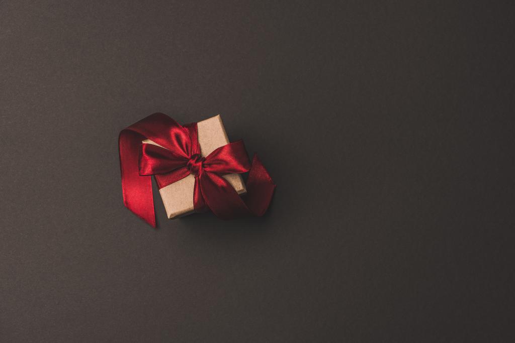 vista superior de la caja de regalo con cinta roja aislada en surfae oscuro
 - Foto, imagen