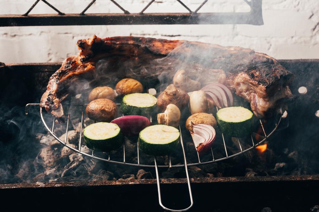 close-up view of delicious meat and vegetables preparing on grill - Photo, Image