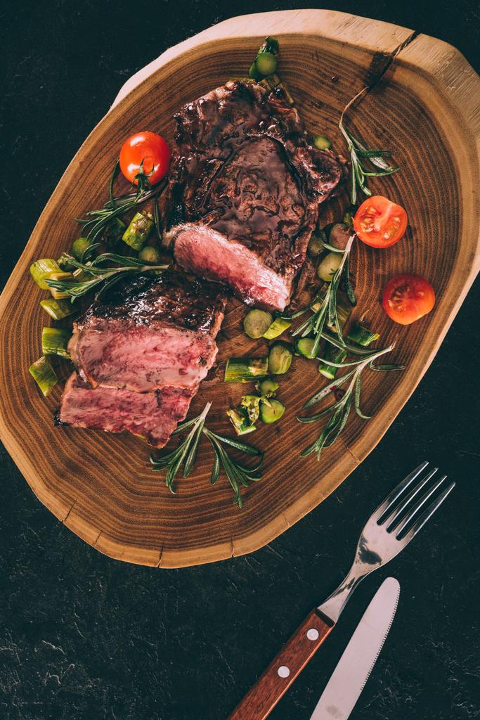 pohled shora gurmánské grilované maso podávané se zeleninou na dřevěné desce - Fotografie, Obrázek