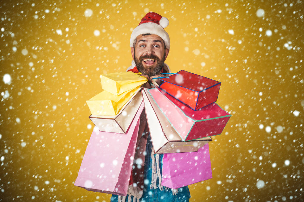 Weihnachtsmann hält Einkaufstüten auf gelbem Hintergrund - Foto, Bild