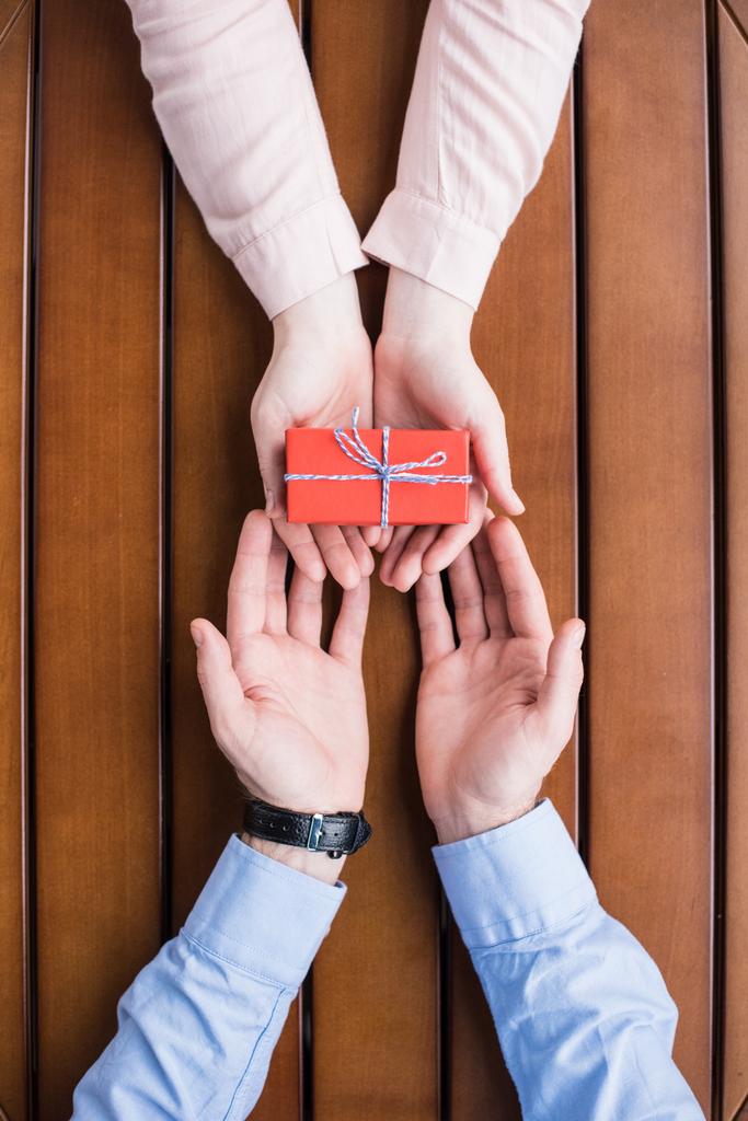cropped image of girlfriend gifting present box to boyfriend - Photo, Image