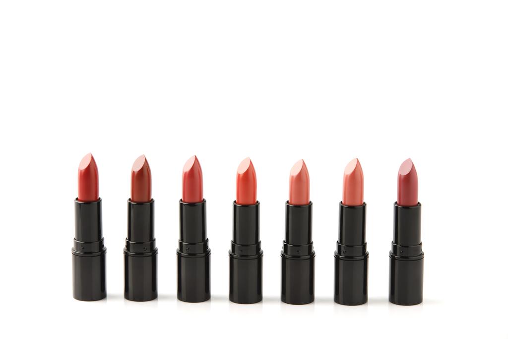 fila de lápices labiales rojos de varios tonos aislados en blanco
 - Foto, imagen