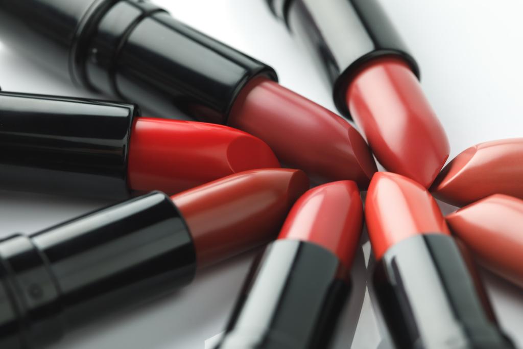 Close-up shot van rode lippenstiften van verschillende tinten op wit tafelblad - Foto, afbeelding