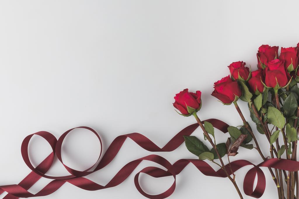 Draufsicht auf schöne rote Rosen mit Band isoliert auf weißem, st valentines day concept - Foto, Bild